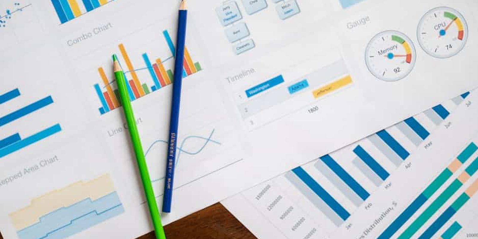 Flat lay of various business charts and colored pencils on wooden table, highlighting financial analysis.