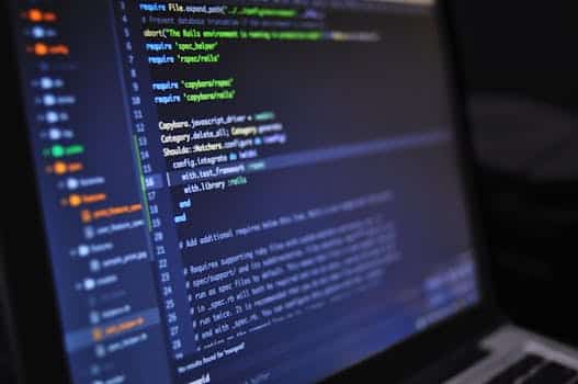 Close-up of a computer screen displaying programming code in a dark environment representing software factory design activity