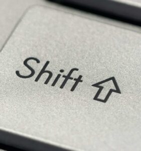Macro photo of a silver keyboard shift key, showcasing detail and texture.